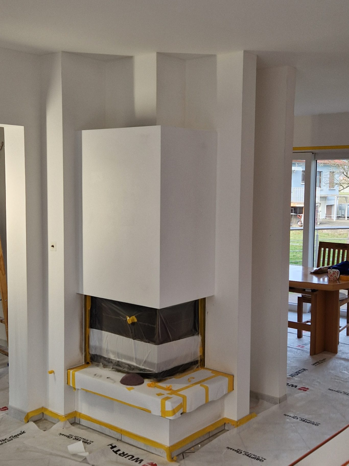 Avant - cheminée Cheminée blanche moderne avec éléments de construction en cours, murs clairs.