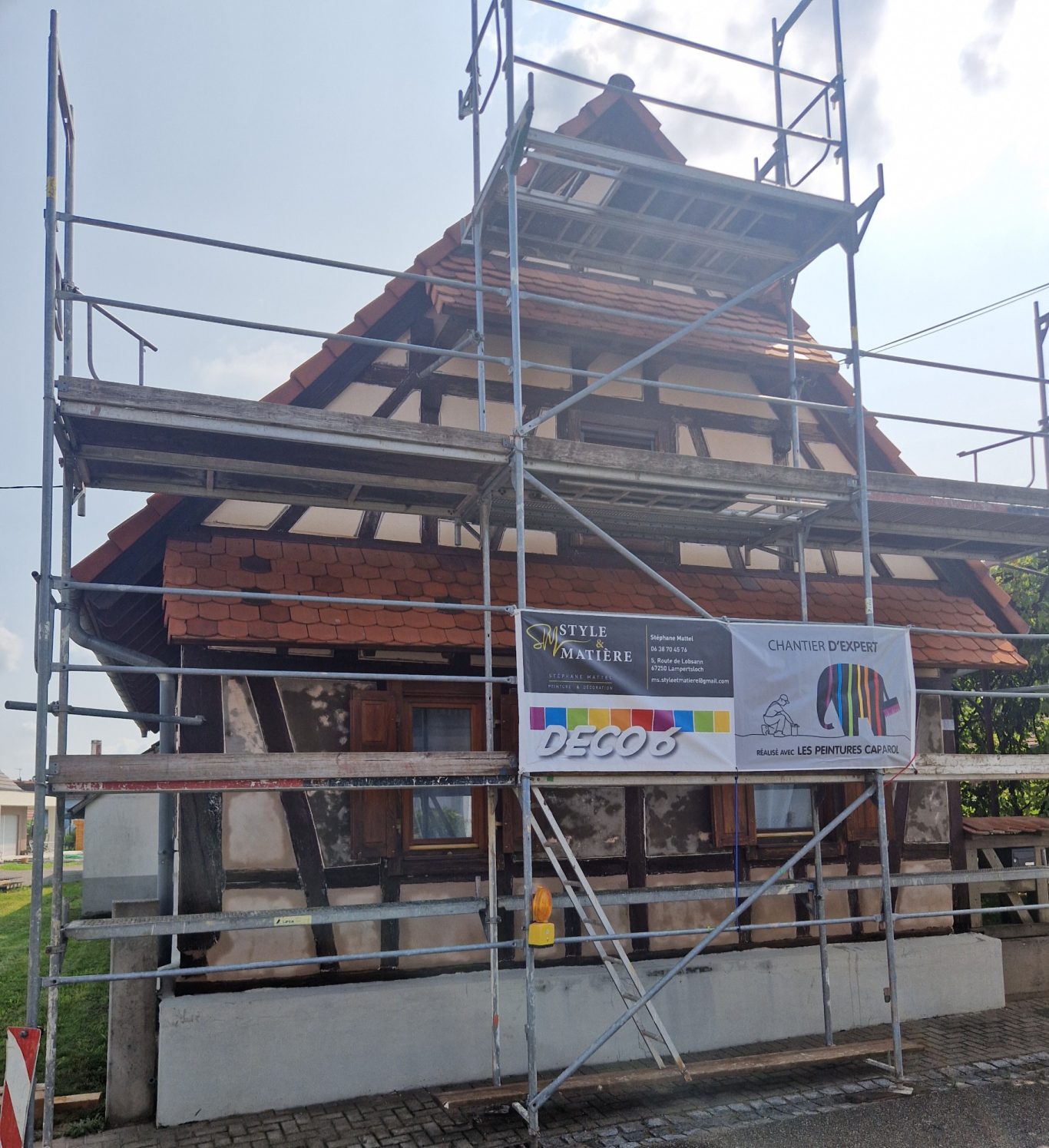 Avant - Facade colombage Maison traditionnelle en cours de rénovation, entourée d'un échafaudage.